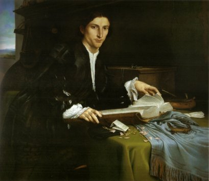 Грустный молодой человек сидит за столом перед открытой книгой